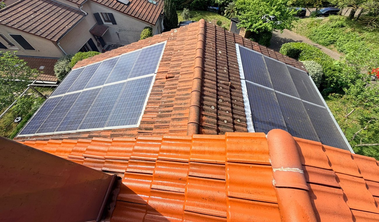 Panneaux solaires posés de part et d'autre du faîtage sur une toiture en tuiles
